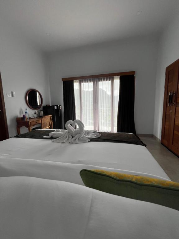 a large white bed in a room with a window at Sidemen padi villas in Silebeng