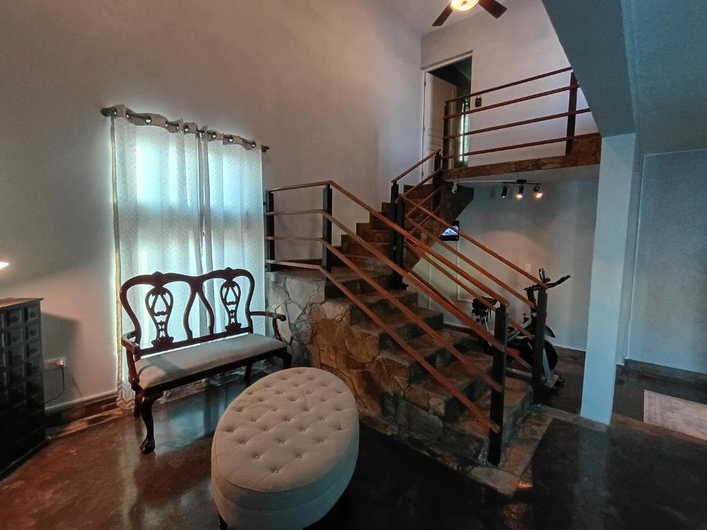 a living room with a spiral staircase and a stool at Casa Kanaph in Reynosa