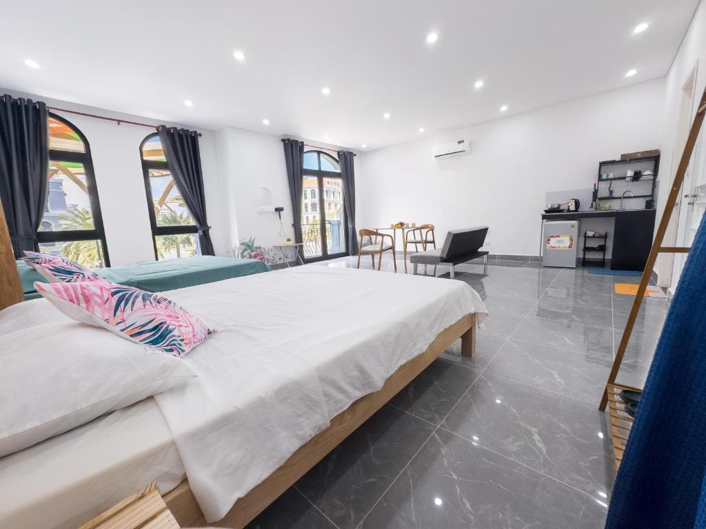 a bedroom with a large bed and a table and chairs at ADRi in Phú Quốc
