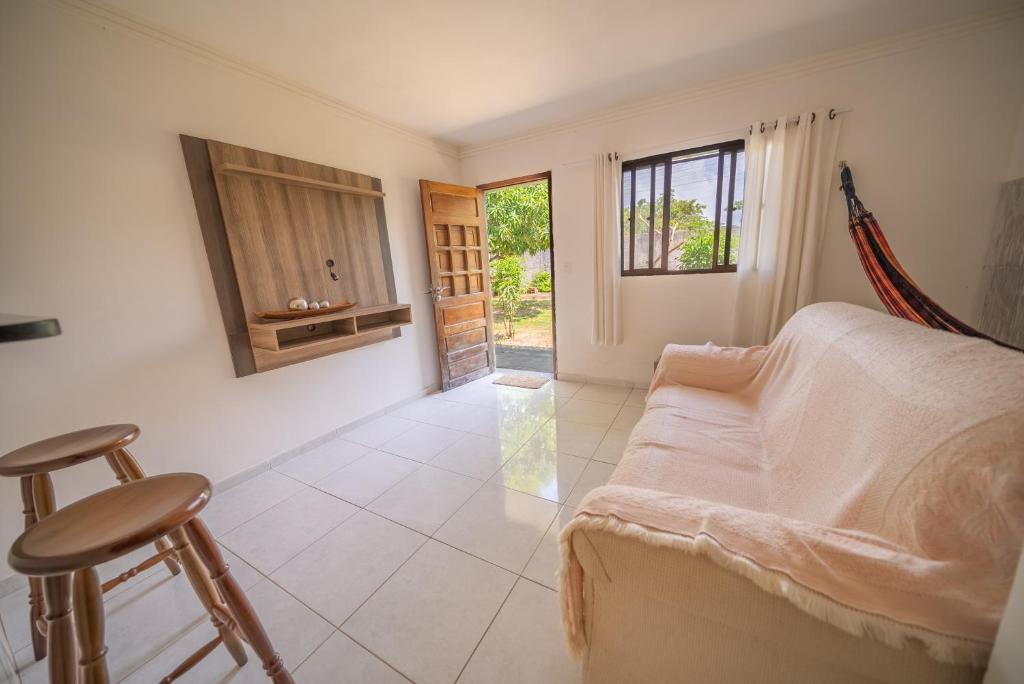 a bedroom with a bed and a table and stool at Casa Queiroz in Porto De Galinhas