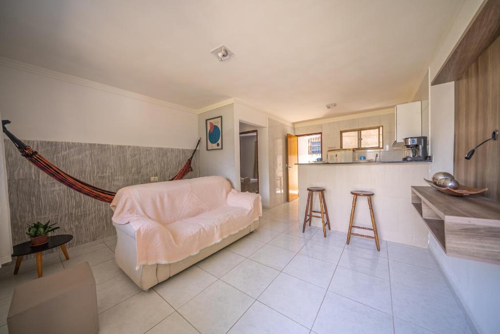 a living room with a couch and a kitchen at Casa Queiroz in Maracaipe