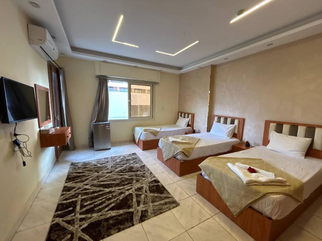 カイロにあるGarden City inn Hotelのベッド2台とテレビがあるホテルの部屋