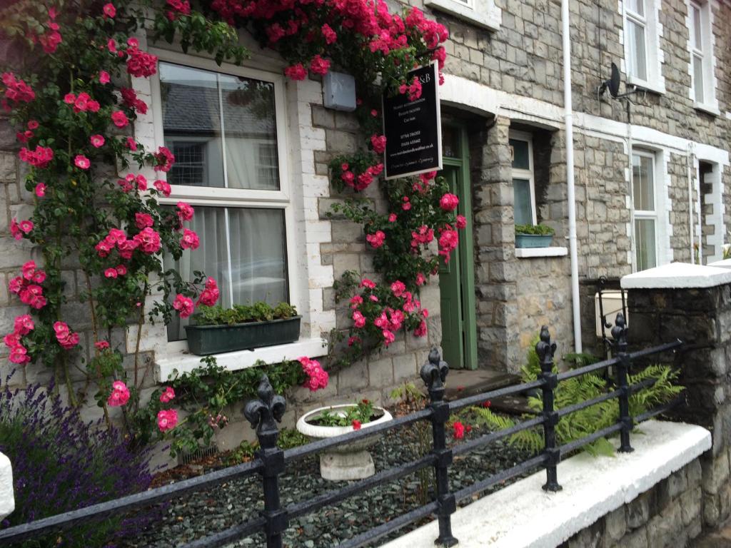 a house with flowers on the side of it at Mairs Bed and Breakfast. in Bridgend