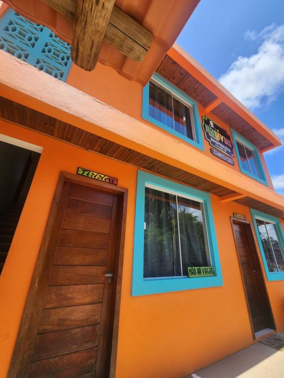 a orange house with a door and windows at Nativus Flats in Itacaré