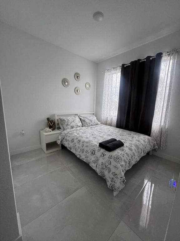 a bedroom with a bed with a black curtain at Modern room with kitchen and backyard access in Homestead