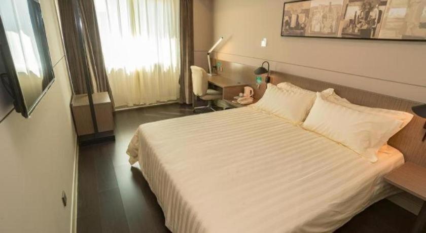 a hotel room with a large bed and a desk at Jinjiang Inn Style Shijiazhuang Zhongshan Xi Road Yuxi Park in Shijiazhuang