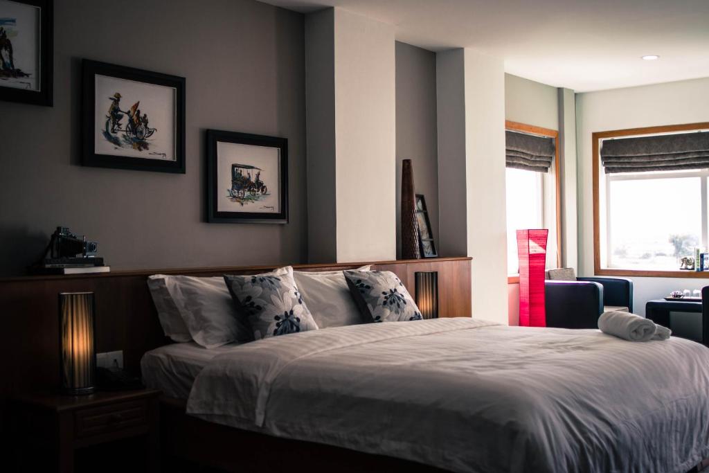 a bedroom with a bed and a window at Point Boutique Hotel in Phnom Penh