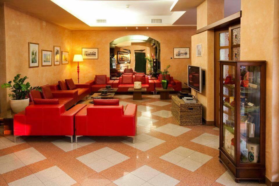 a living room with red couches and a television at Hotel Valbrenta in Limena