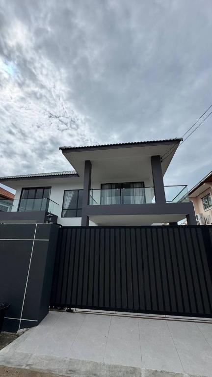 una casa con una puerta negra y una valla en New premium Pool Villa 5 bedroom, en Jomtien Beach