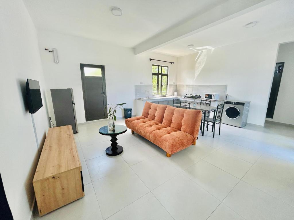 a living room with an orange couch and a table at Accacia Residence in Post of Flacq