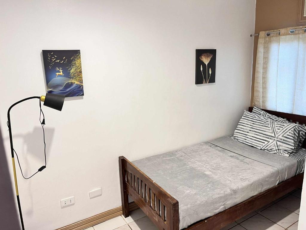a small bedroom with a bed and a lamp at Ace Travellers Inn- Palawan in Puerto Princesa City