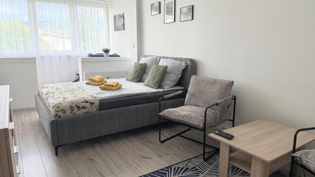 Un pequeño dormitorio con una cama y una silla. en Apartament KOREK, en Stronie Śląskie