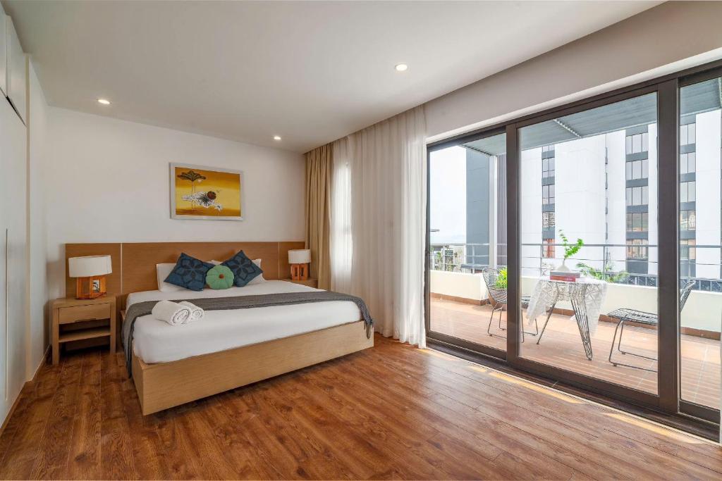Un dormitorio con una cama y una gran puerta corrediza de vidrio. en Luxury apartment ICON40 near beach, en Ha Long