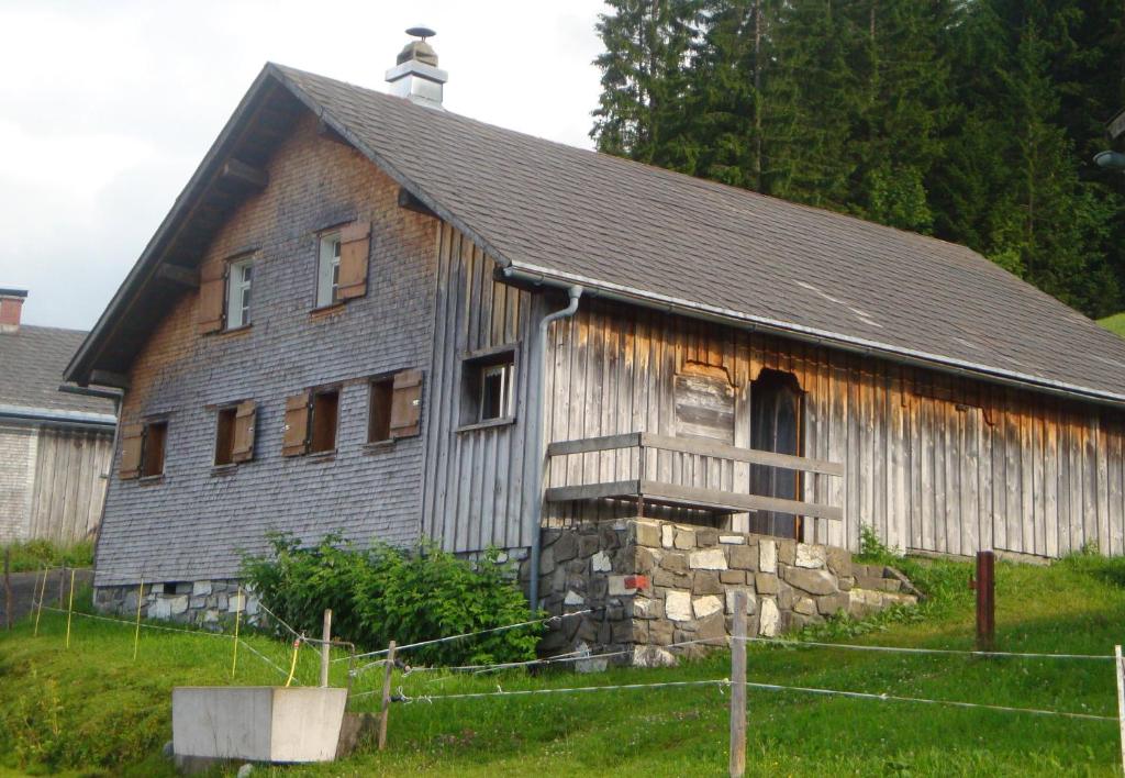 um velho celeiro de madeira com um telhado de metal em UNSER VORSÄSS - Klausberg em Schwarzenberg im Bregenzerwald