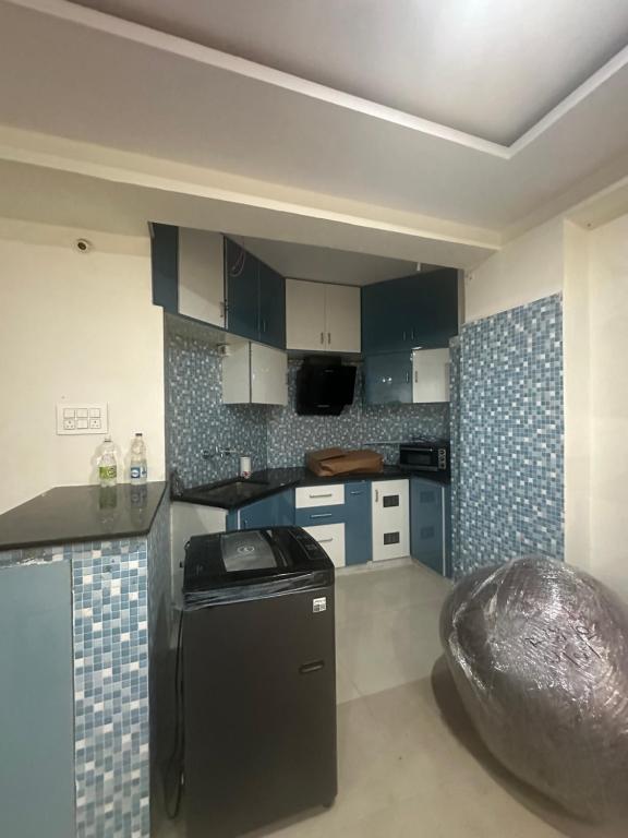 ヴィシャカパトナムにあるSri Dutta Residencyのキッチン(青いキャビネット、黒いカウンタートップ付)