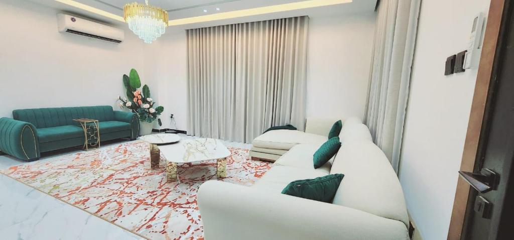 ein Wohnzimmer mit einer weißen Couch und einem Tisch in der Unterkunft EkDatta-Irving in Ajman 