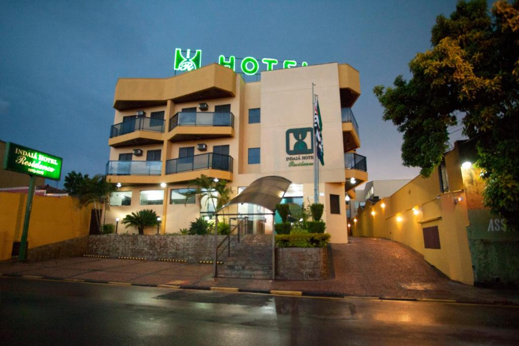 a building with a neon sign in front of it at Indaiá Hotel Residence in São Carlos