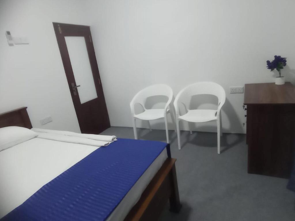 1 dormitorio con 2 sillas, 1 cama y escritorio en Casa Tranquila, en Talalla South