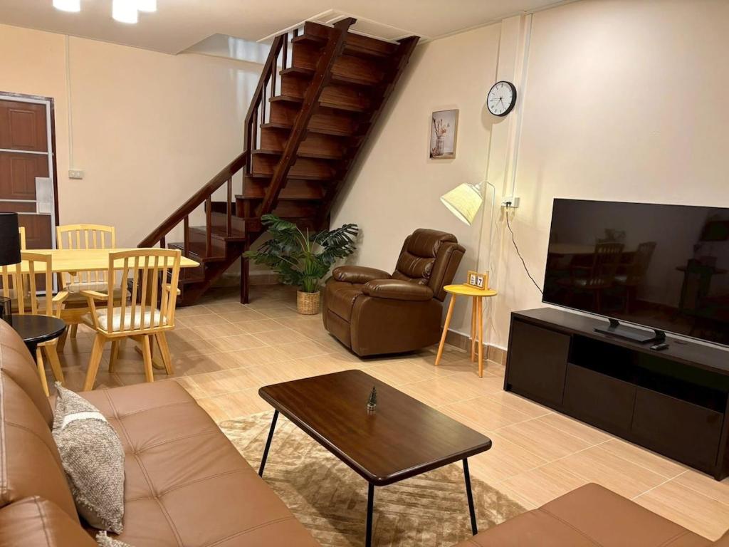 Una sala de estar con un sofá y un televisor. en Golden Heaven, en Suratthani