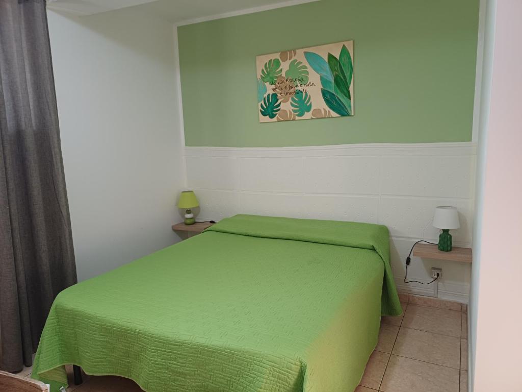 - une chambre avec un lit vert dans l'établissement Confort home, à Rende