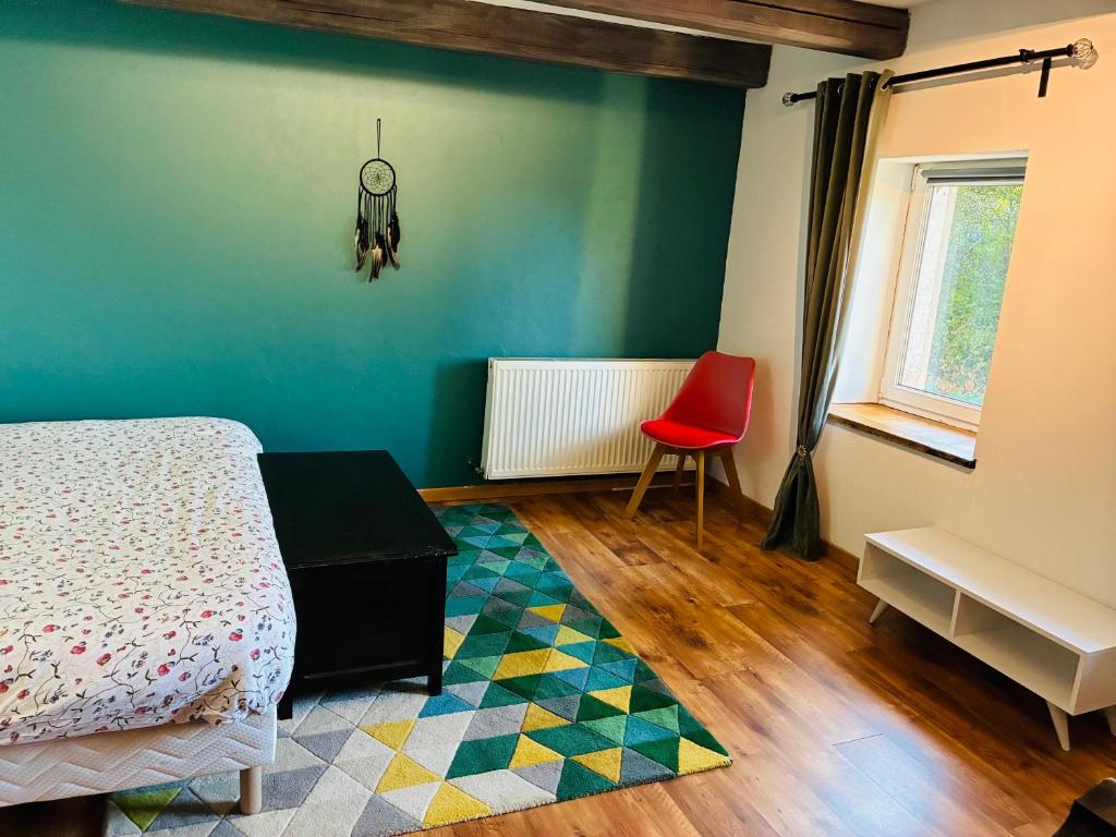 a bedroom with a bed and a red chair at La casa di Alba-Salomé in Métairies-Saint-Quirin