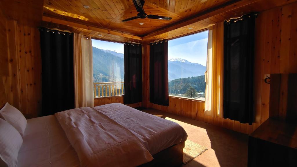 a bedroom with a bed and a large window at Aurora Grove in Manāli