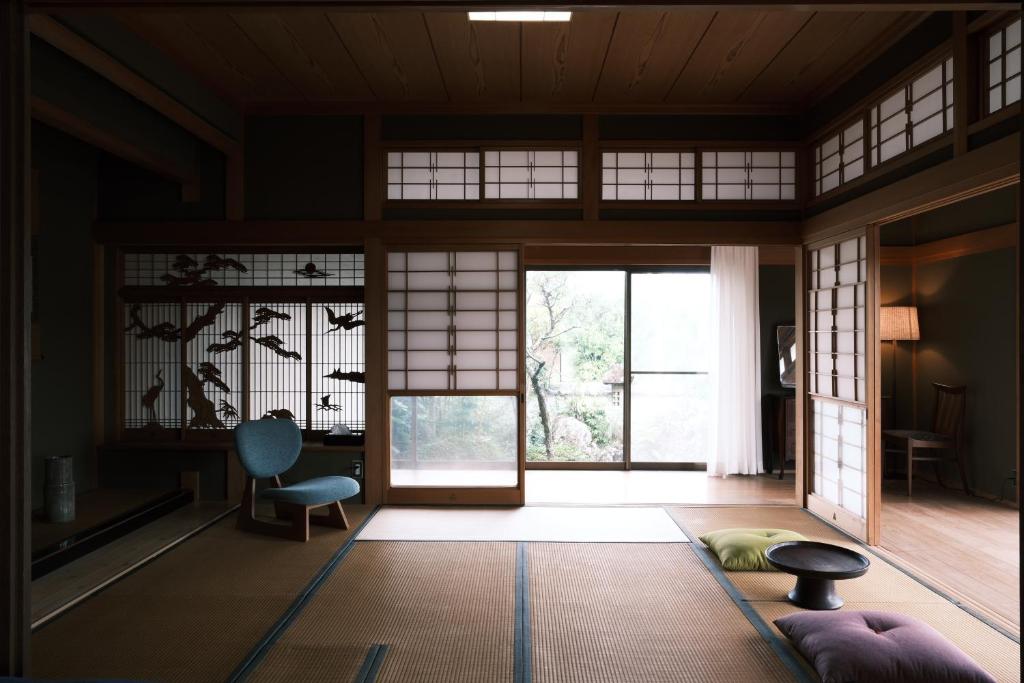 Una habitación japonesa con una puerta y una silla. en Shimanto Suite By Hideaway, en Shimanto