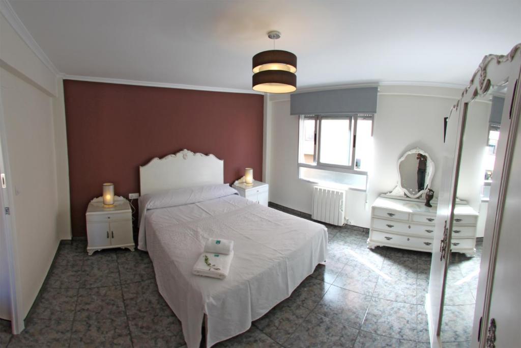 1 dormitorio con cama blanca y espejo en Apartamento El Mirlo Blanco, en Villena