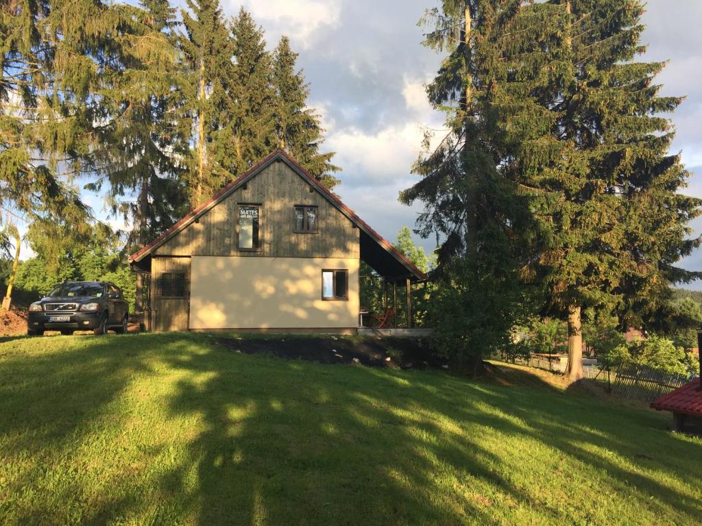 una casa en un césped verde con un árbol en Chalupa Mates Černý důl en Cerny Dul