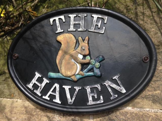 Una señal que dice el haveix con una ardilla. en The Haven en Rothbury