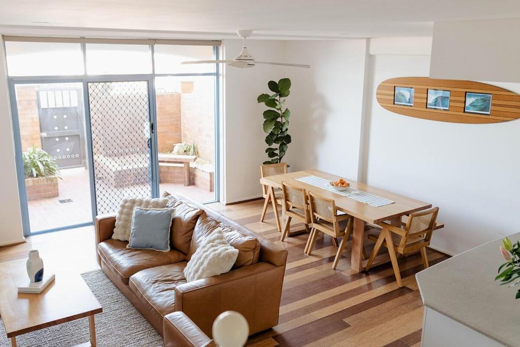 ニューカッスルにあるBeachfront Getaway with Views, Pool & Tennis Courtのソファとテーブルのあるリビングルーム