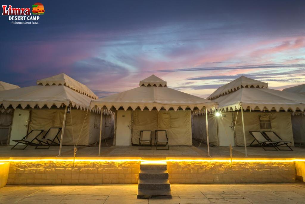 un groupe de tentes avec des chaises à l'intérieur la nuit dans l'établissement Samluxurydesertcamp, à Sām