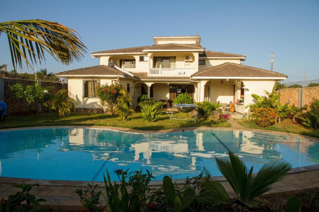 a house with a swimming pool in front of it at Lisa Mari in Mombasa
