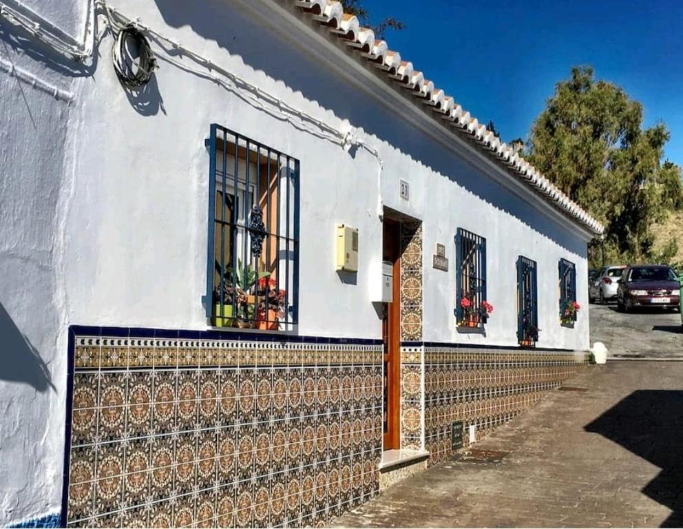 ein weißes Haus mit einem Zaun davor in der Unterkunft La Casita in Torrox