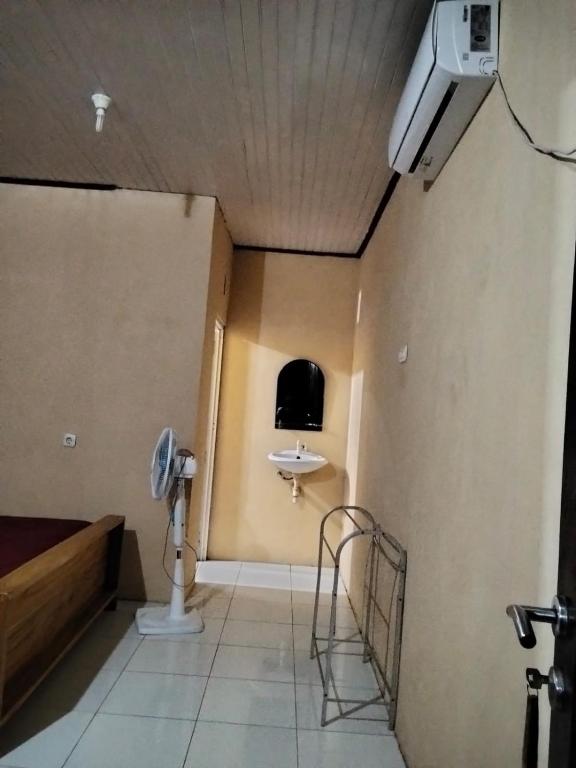 a room with a sink and a bed in a room at Homestay Mamalis in Bunaken