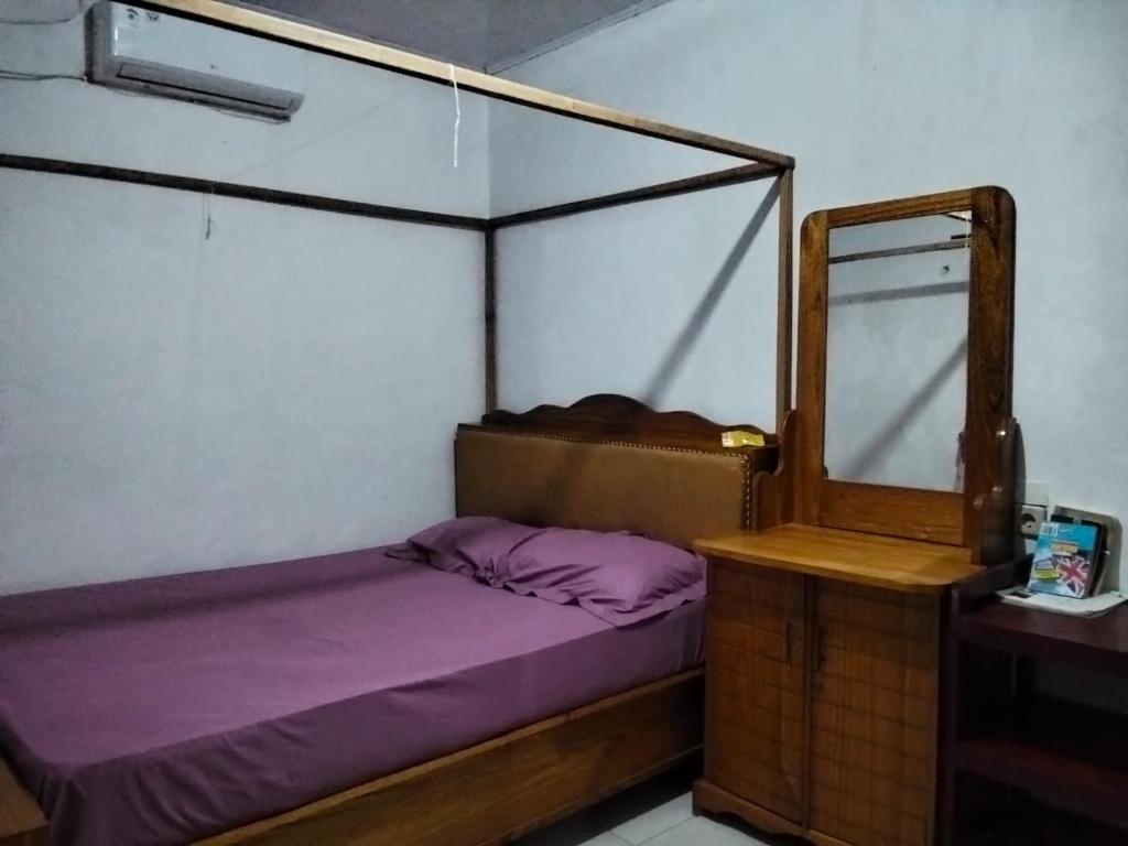 a bedroom with a canopy bed and a mirror at Homestay Mamalis in Bunaken
