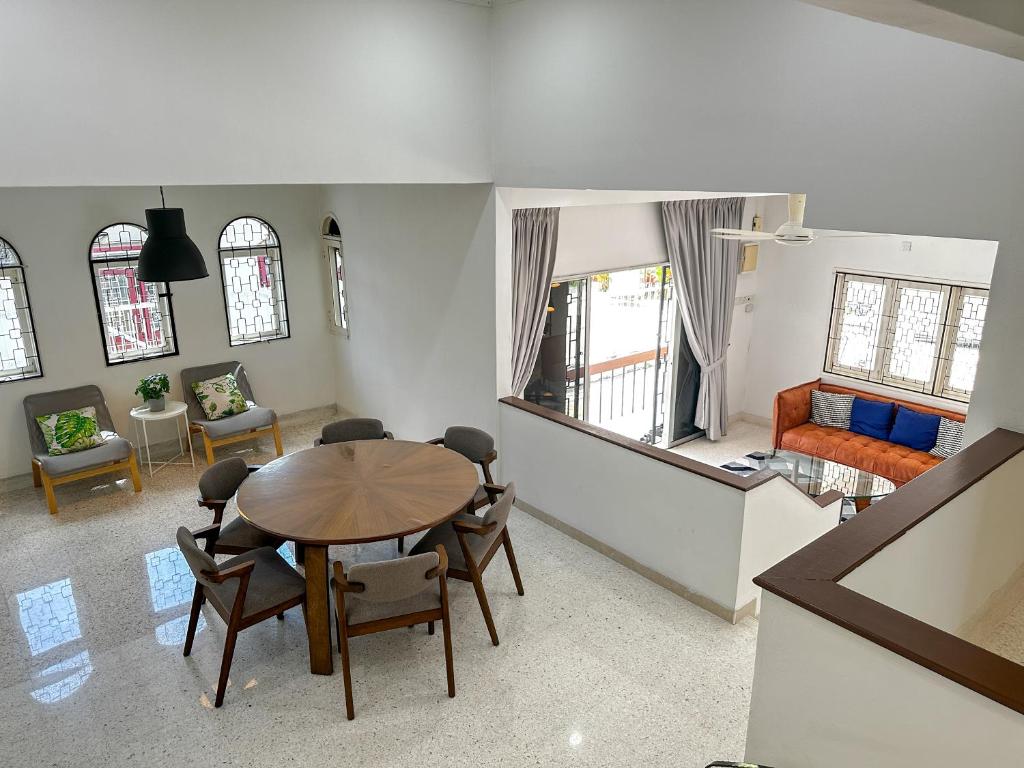 una sala de estar con una mesa y sillas en Modern Garden View Bungalow In Seremban by Maison, en Seremban