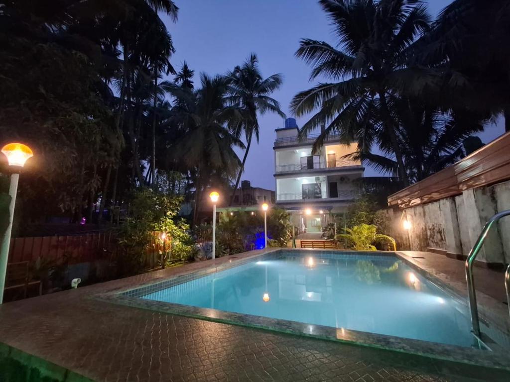 ein Schwimmbad vor einem Gebäude bei Nacht in der Unterkunft STARFISH Resort in Nagaon