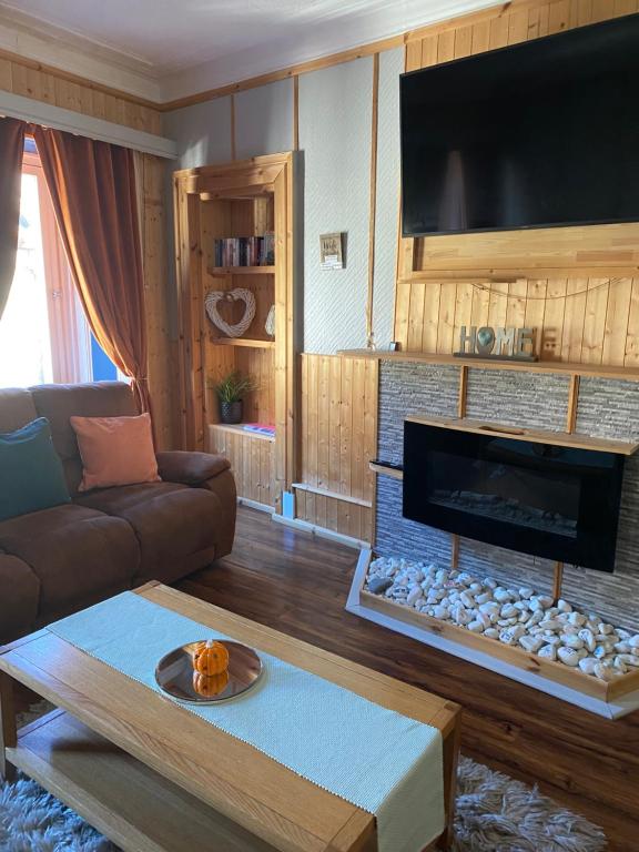 un salon avec un canapé et une cheminée dans l'établissement Georges holiday apt the blue suite, à Inverness