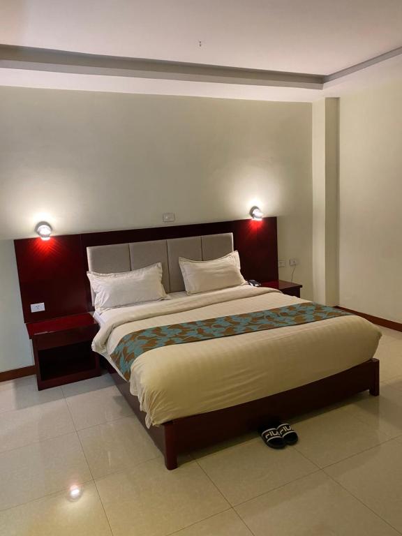 a bedroom with a large bed with two lights on it at Wynn hotel in Bahir Dar