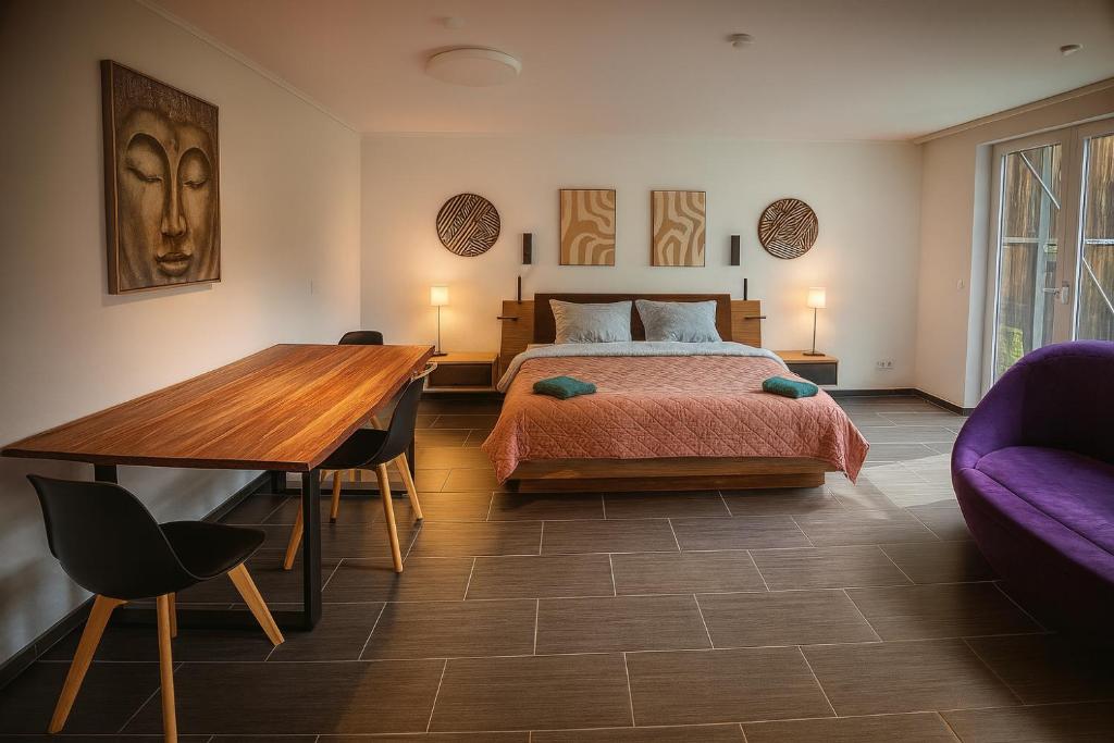 a bedroom with a bed and a wooden table at Luxury Amour Suite Modern Design mit Terrasse in Koblenz