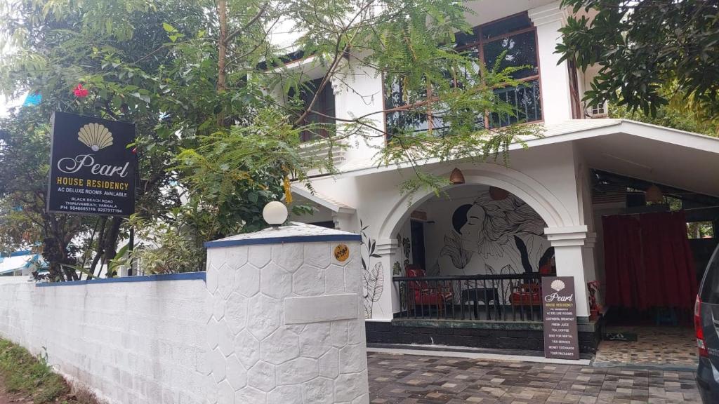 a white building with a sign in front of it at Pearl House Residency in Jāmb