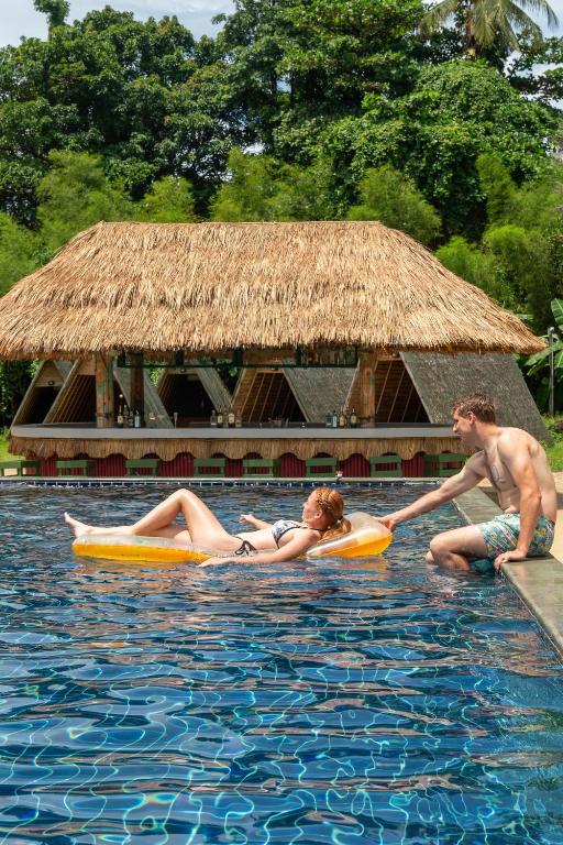 a man and a woman in the water at a swimming pool at Slumber Resort Koh Chang in Ko Chang