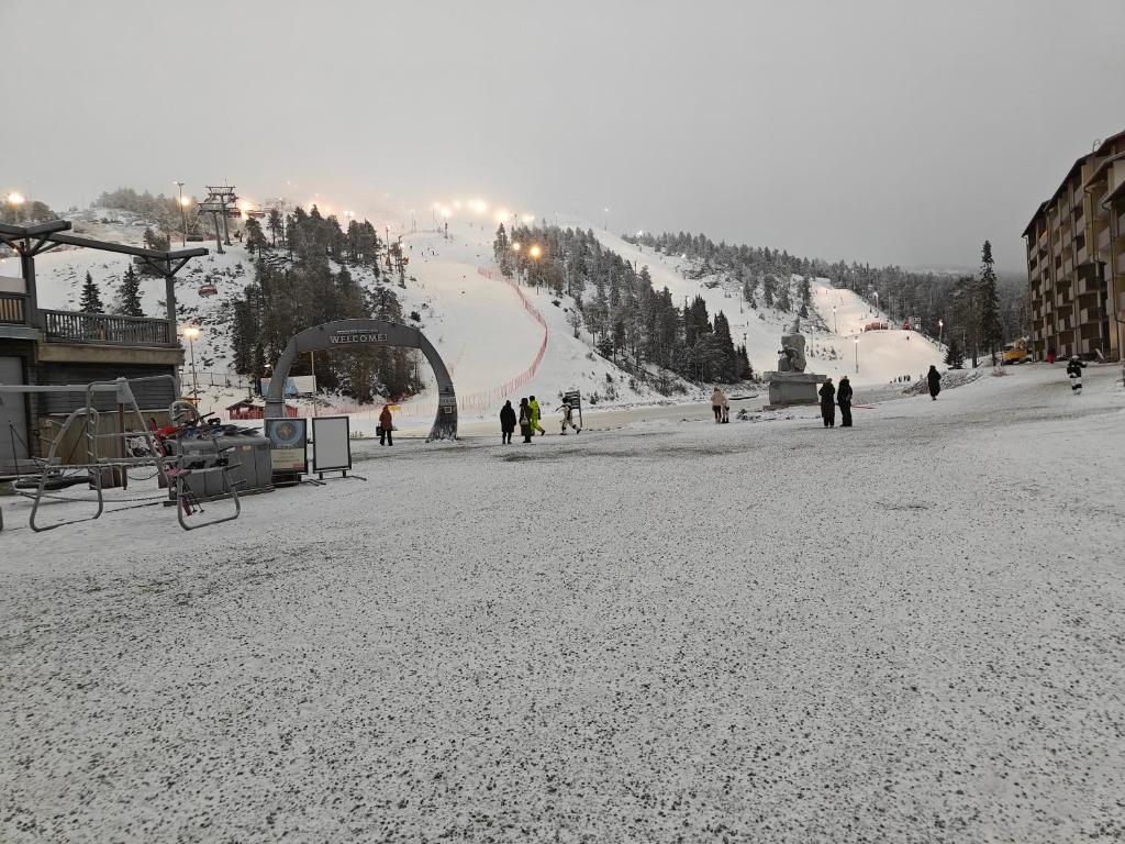 a snow covered ski slope with people on it at Kuusamon Lampitropiikki 108 m2 Holiday Home in Kuusamo