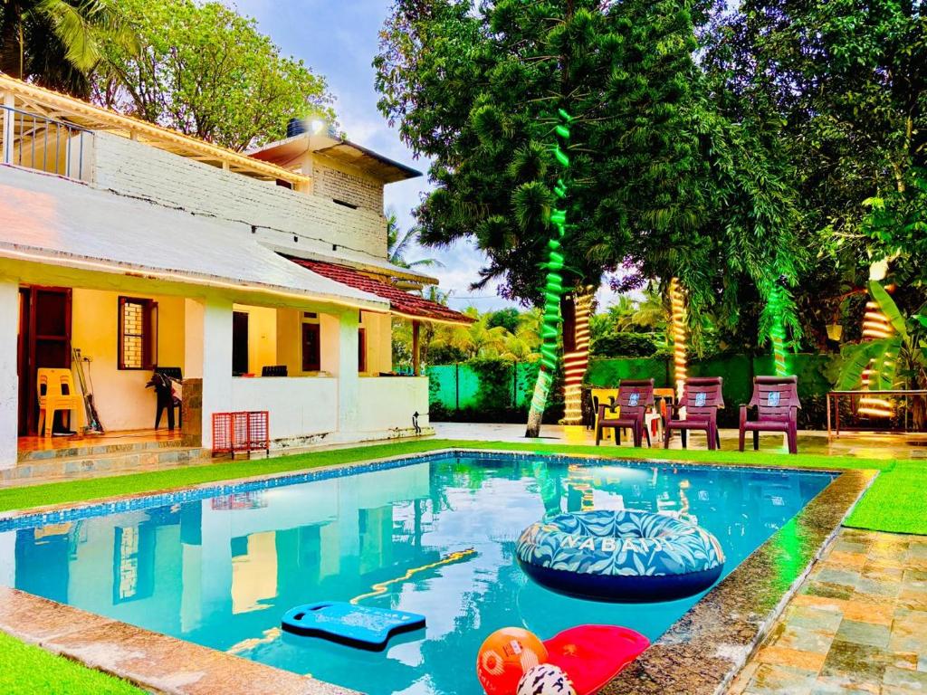 a swimming pool in the yard of a house at Oceanwood Beachfarm Alibaug in Nagaon