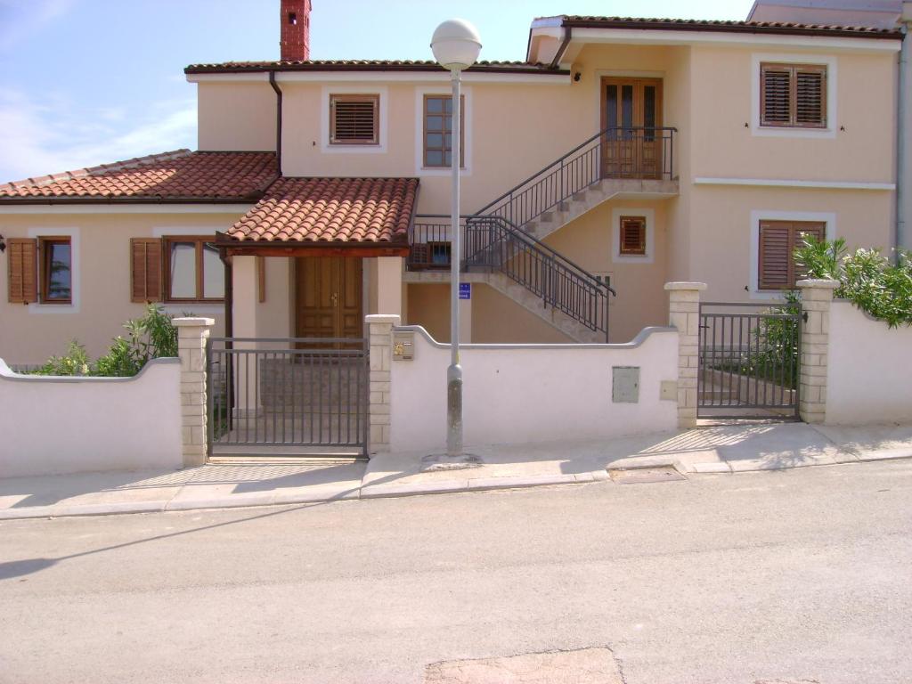 ein weißes Haus mit Treppen und einem Tor in der Unterkunft Villa Marianne in Vinkuran