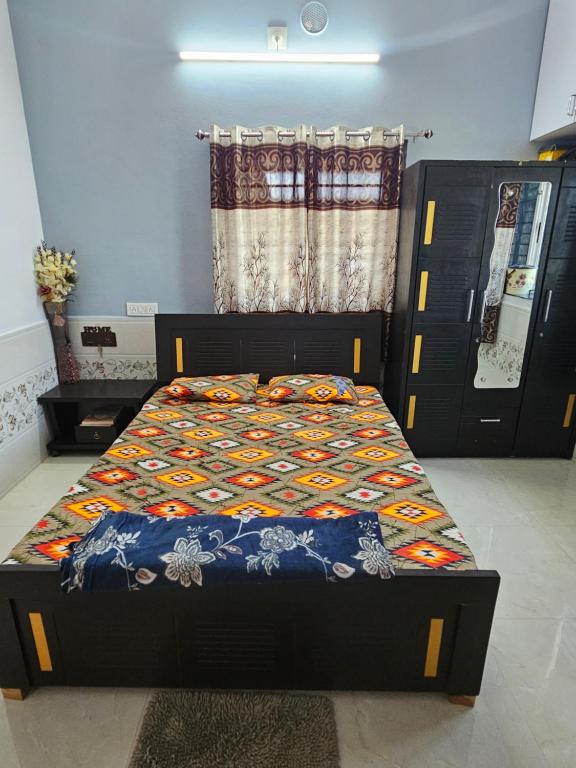 een bed met een quilt erop in een kamer bij Home stay Hotel in Diu