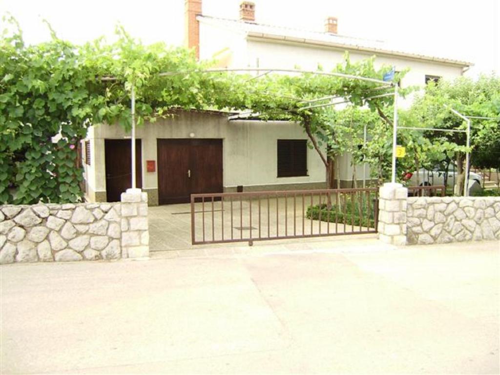 a house with a gate in front of a building at House Krk in Krk