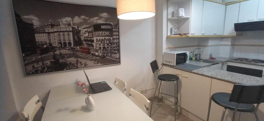 a kitchen with a table with a laptop on it at Tramuntana Beach in Calafell