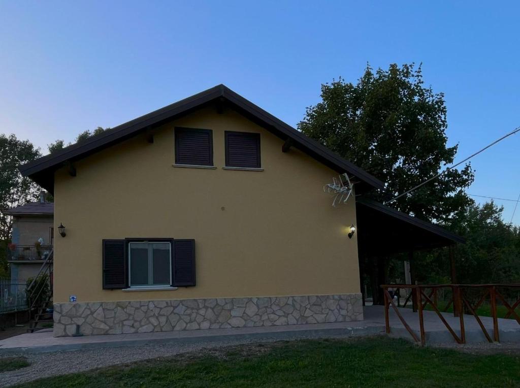 a yellow house with a black roof at Guzzolini Camere & Relax in Camigliatello Silano